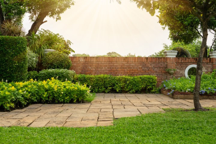 Garden with natural stone pavers in Toorak VIC